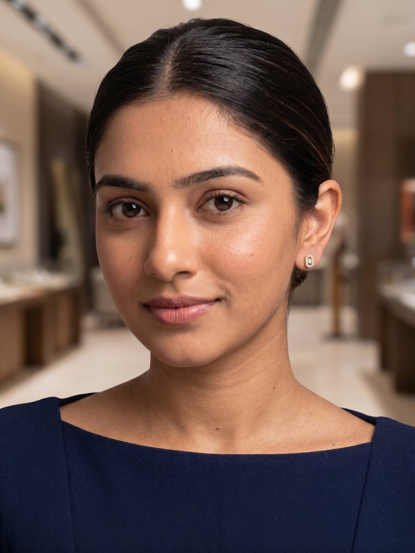 Woman wearing earrings in a blurred interior setting