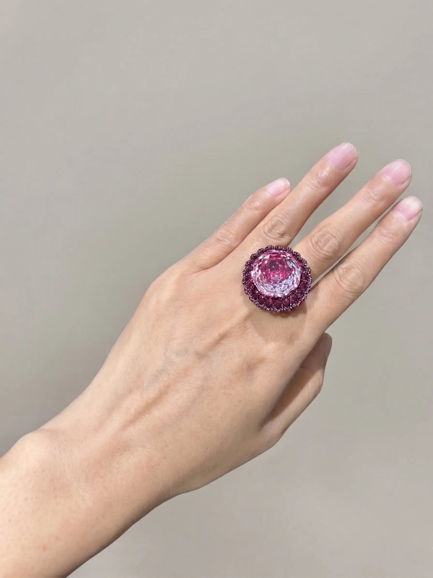 High-angle view of an ornate, black-plated ladies ring featuring a vivid, rose-cut Swarovski finger ring styled magenta stone with exceptional eye-clean clarity
