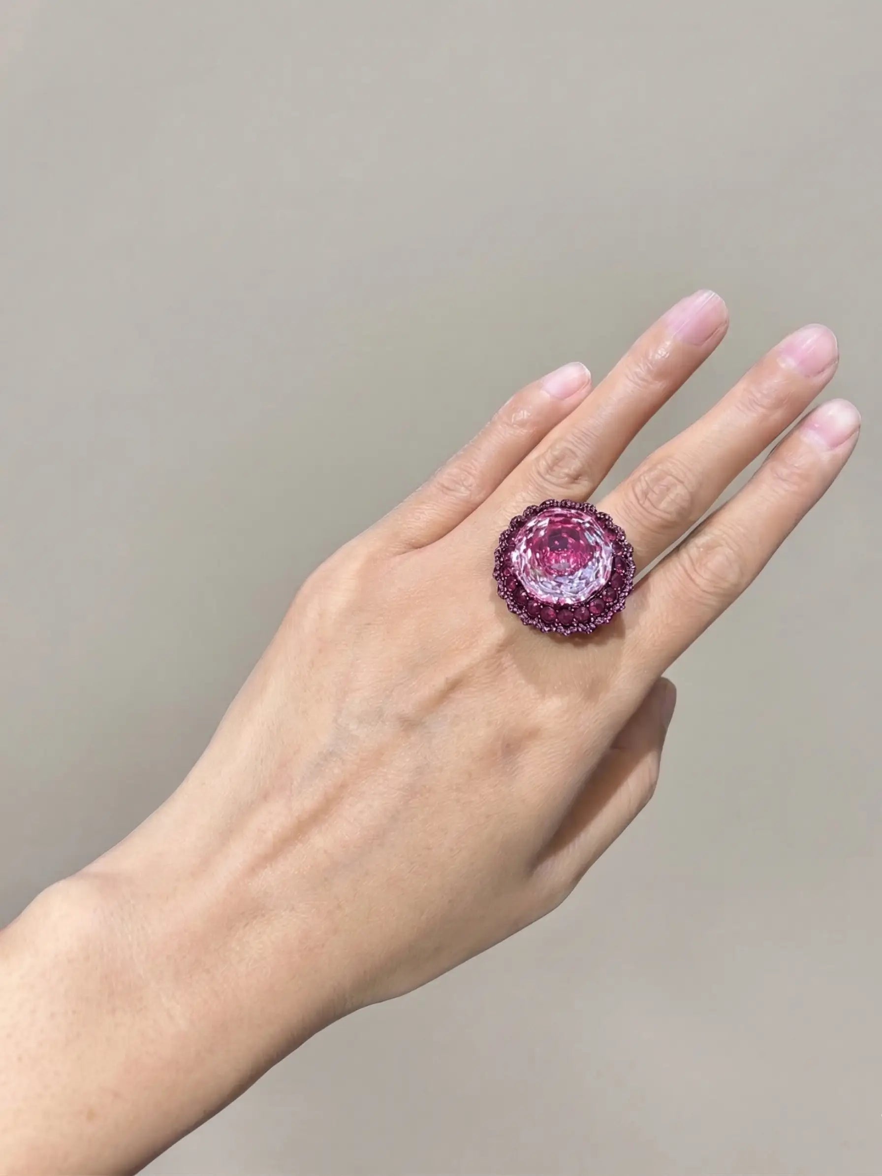 High-angle view of an ornate, black-plated ladies ring featuring a vivid, rose-cut Swarovski finger ring styled magenta stone with exceptional eye-clean clarity