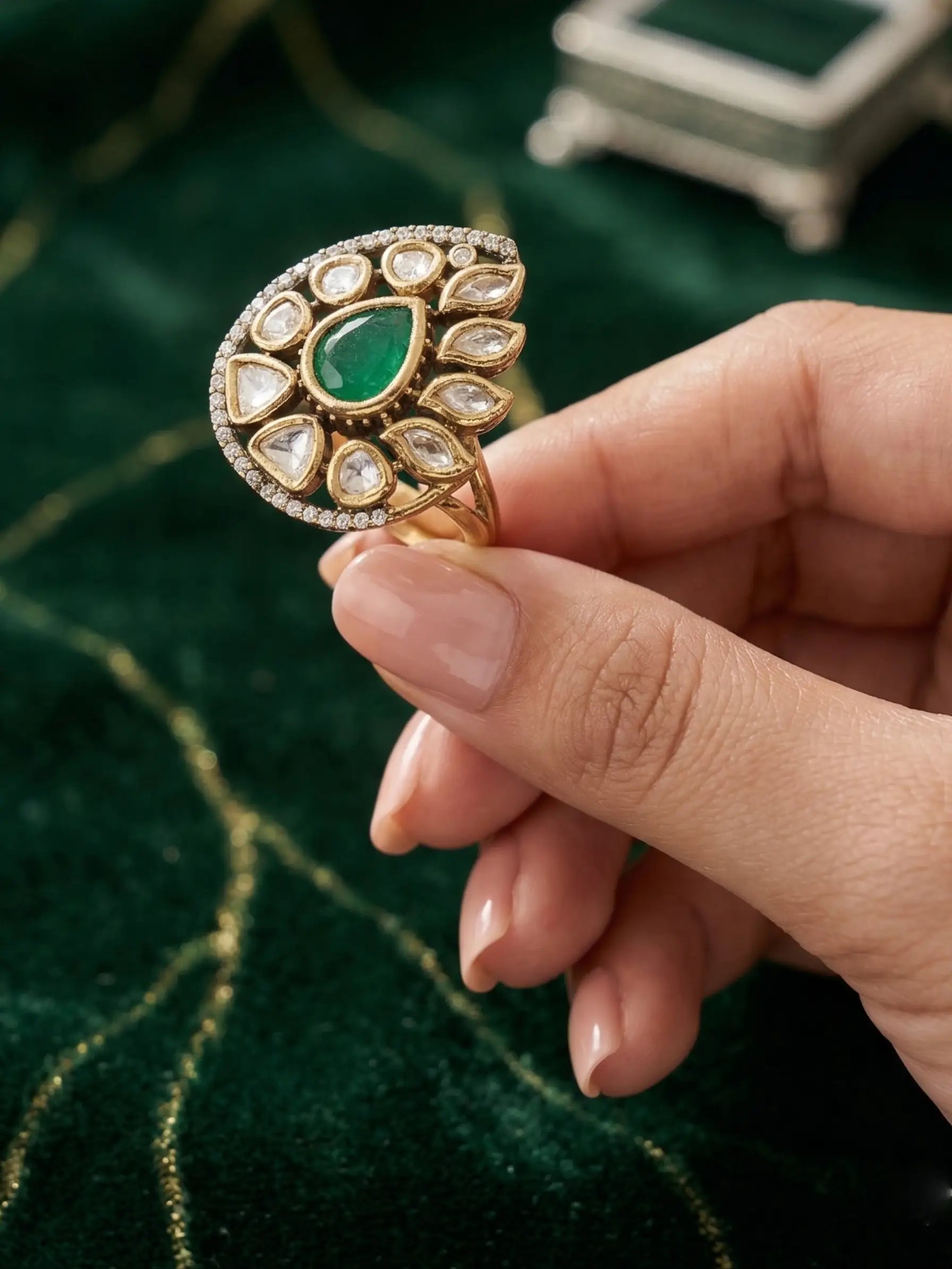 Large teardrop-shaped kundan fashion ring for ladies paired with an emerald green saree