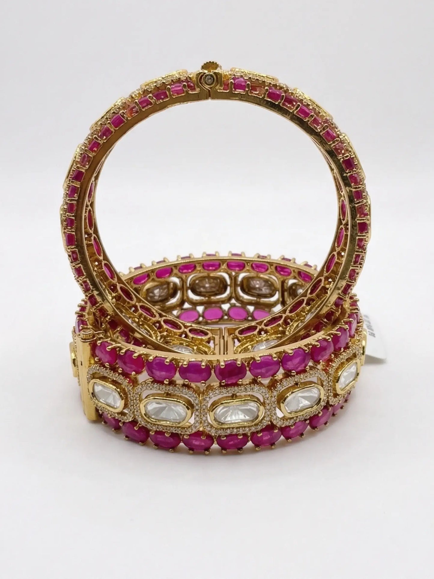 screw bangles with pink and white stones on a white background