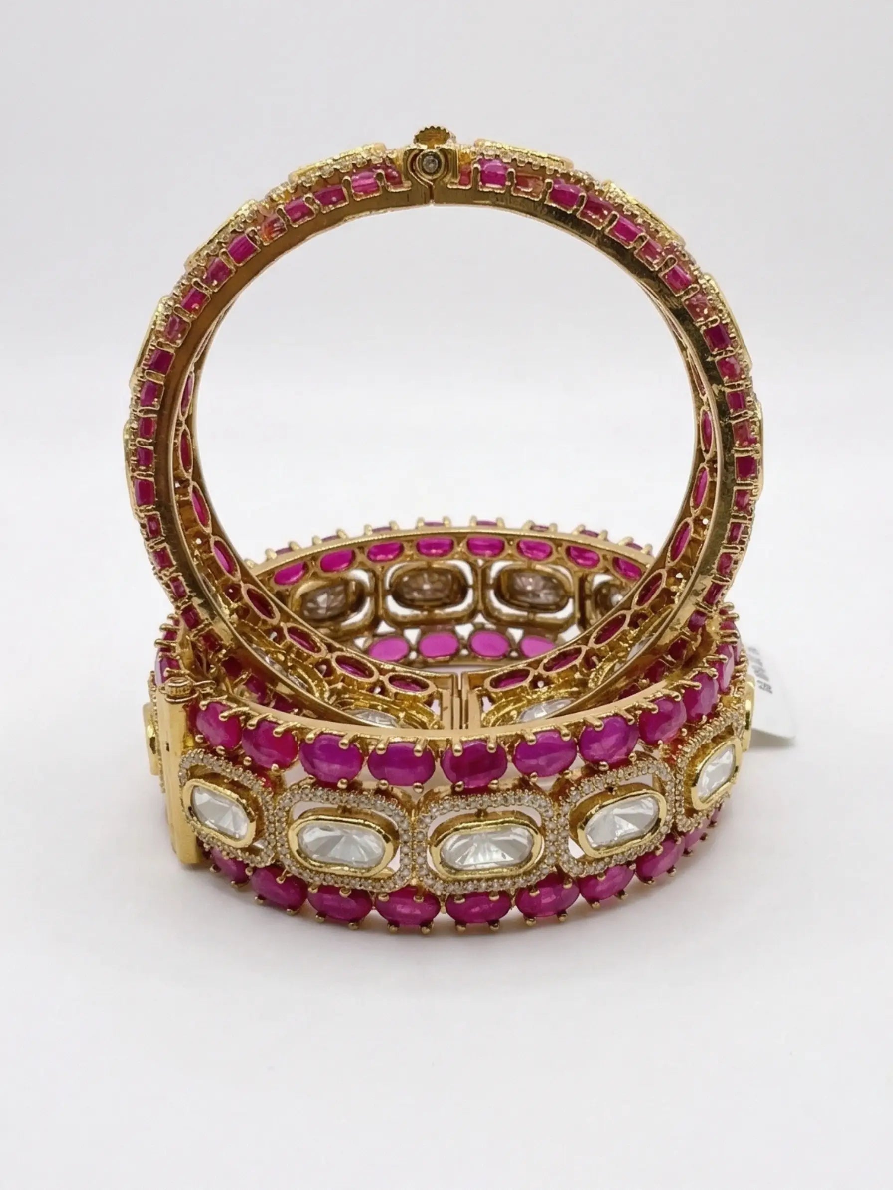 screw bangles with pink and white stones on a white background